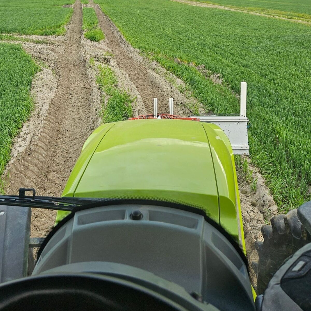 En grøn traktor der kører på en græsmark
