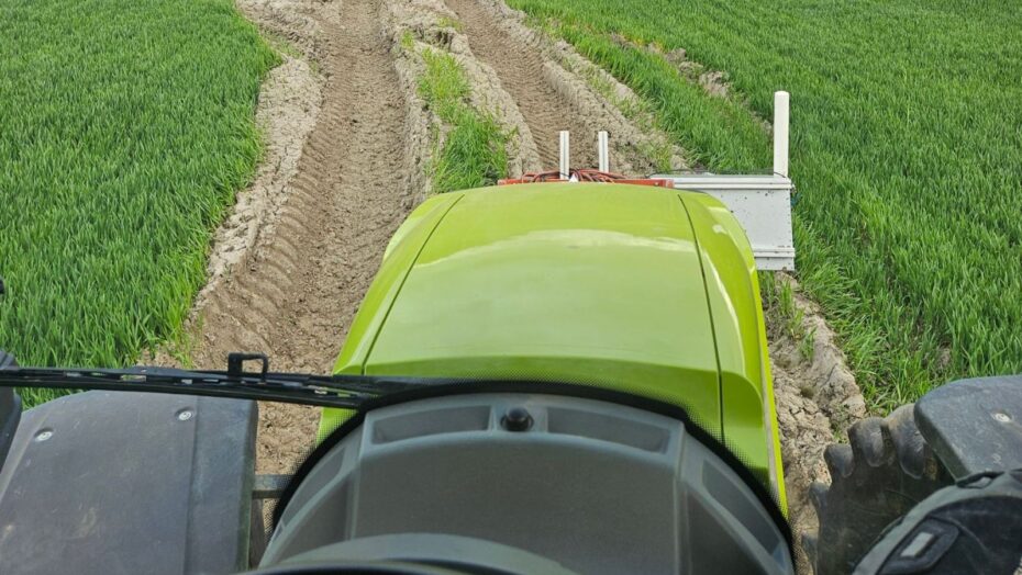 En grøn traktor der kører på en græsmark