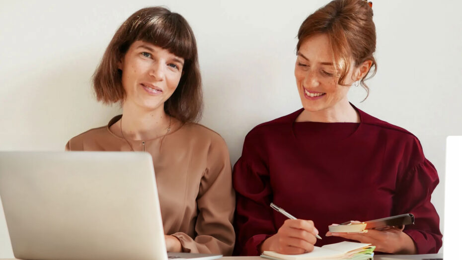 To yngre kvinder der sidder og arbejder på en laptop