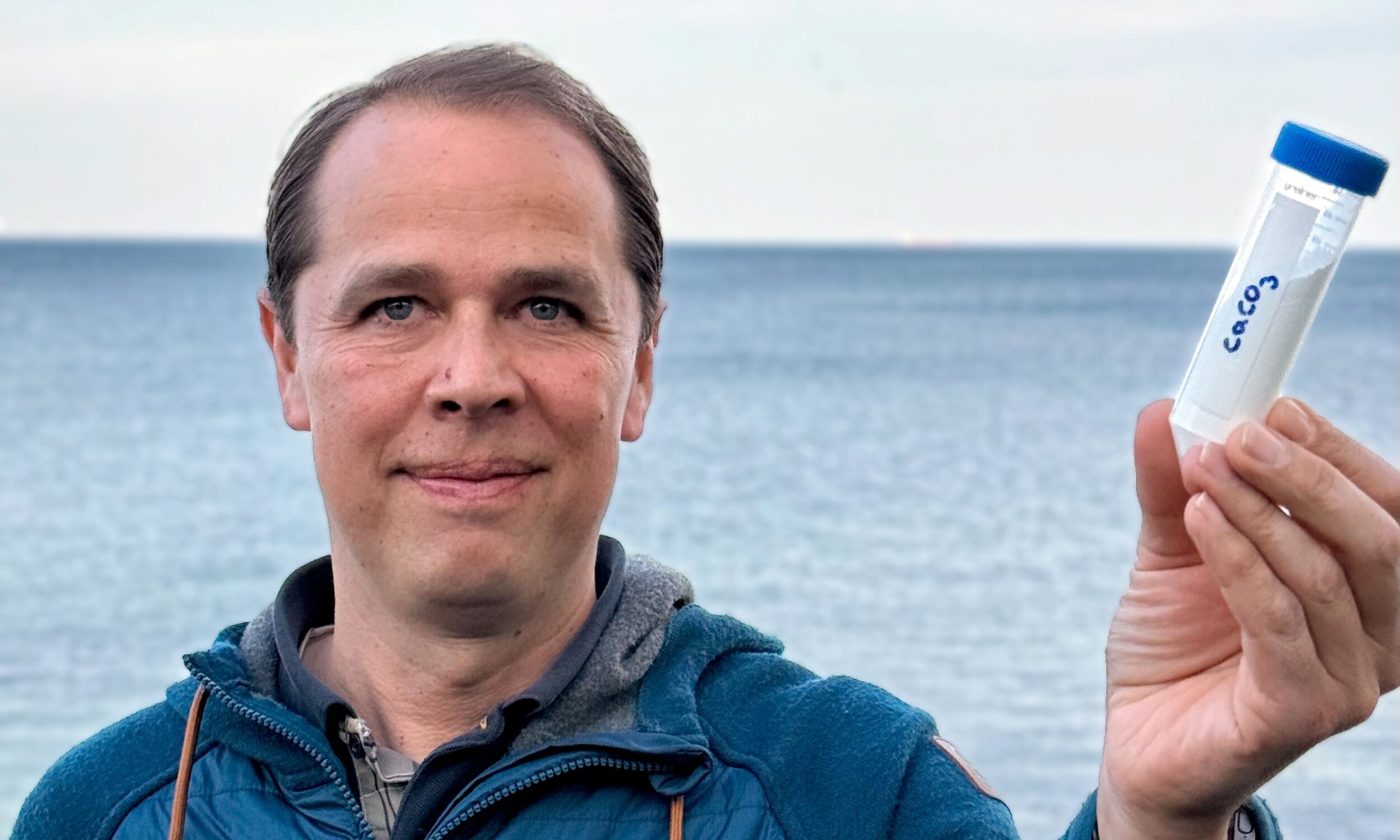En forsker der holder en beholder i hånden