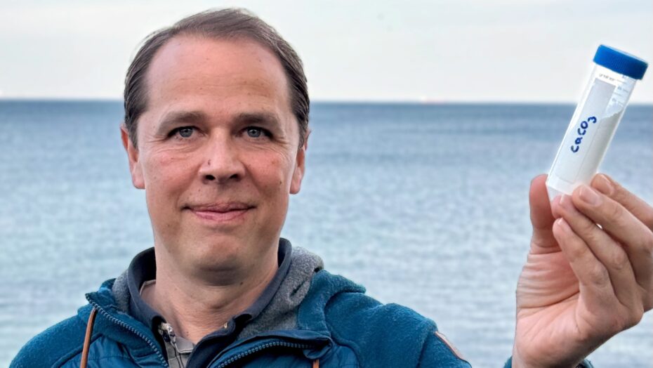 En forsker der holder en beholder i hånden