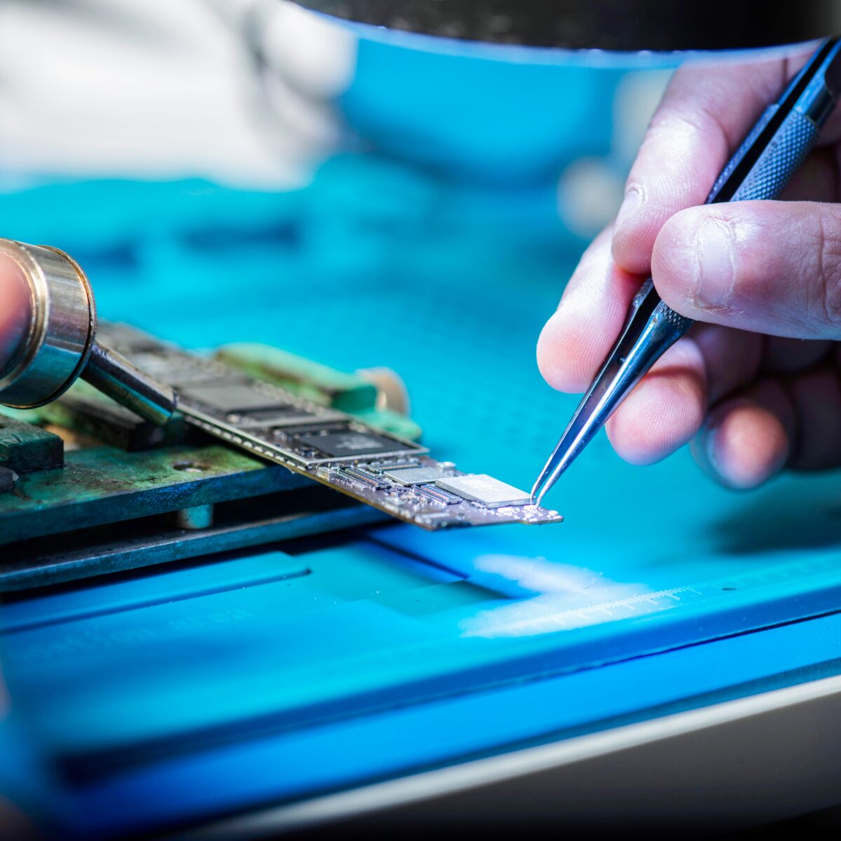 en hånd der bruger en pincet til at ordne en computerchip